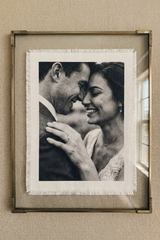 Framed black and white photograph of a couple on a textured wall.